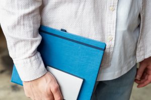 imagem mostra um homem segurando documentos