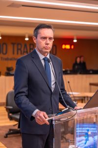 Homem com terno escuro falando ao púlpito