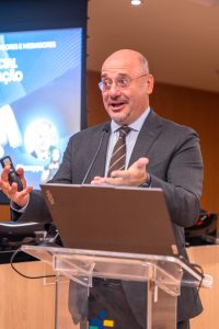 Homem vestindo terno fala ao púlpito durante palestra