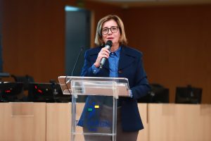 Mulher de terno ao microfone em um púlpito