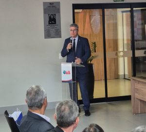 Homem falando ao microfone em frente ao púlpito