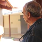 imagem mostra um idoso de costas olhando para o horizonte