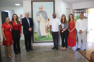 imagem mostra o desembargador Welington Peixoto com sua equipe e o padre Geovani Pereira dos Santos com alguns membros da sua equipe