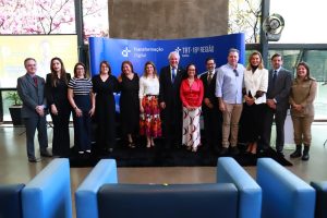 Várias pessoas em pé posando para foto em um ambiente fechado