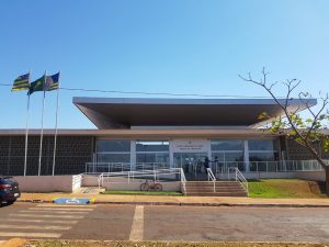 Foto da fachada do Foro do Itumbiara. O prédio possui paredes brancas e janelas de vidro. Na entrada há duas escadas e uma rampa de acesso. Acima da porta de entrada, o texto "Poder Judiciário da União - Varas do Trabalho".