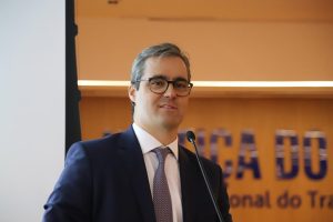 Homem de terno fala ao microfone