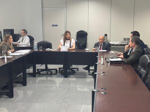 Várias pessoas sentadas numa mesa de negociação