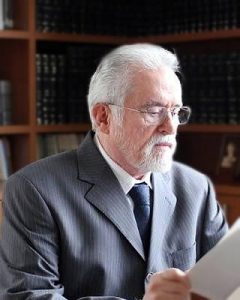 Homem usando terno e óculos lê um documento