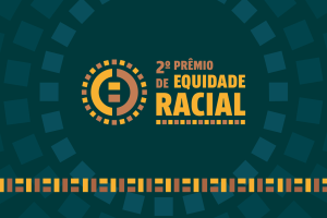 Imagem em fundo verde escuro. No centro, o texto "2º Prêmio de Equidade Racial" escrito em amarelo e laranja.