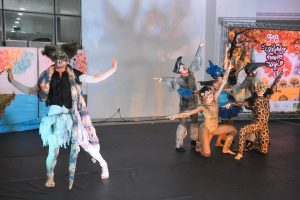 Foto de sete atores durante apresentação teatral infantil. Eles estão caracterizados como animais do Cerrado.