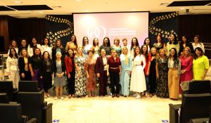 Foto de 35 mulheres durante o 6º Cojum. Elas estão de pé, lado a lado, sorrindo e posando para foto.