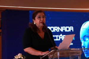 Mulher discursando na frente de um púlpito.