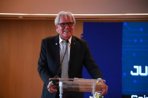 Homem discursando em frente a um púlpito.