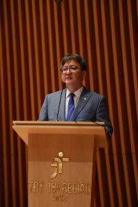 Homem vestindo terno fala ao púlpito 