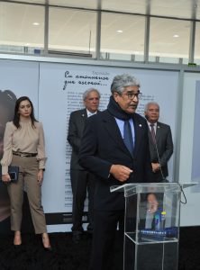 Homem de terno fala ao microfone