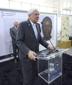 Homem vestindo terno fala ao microfone